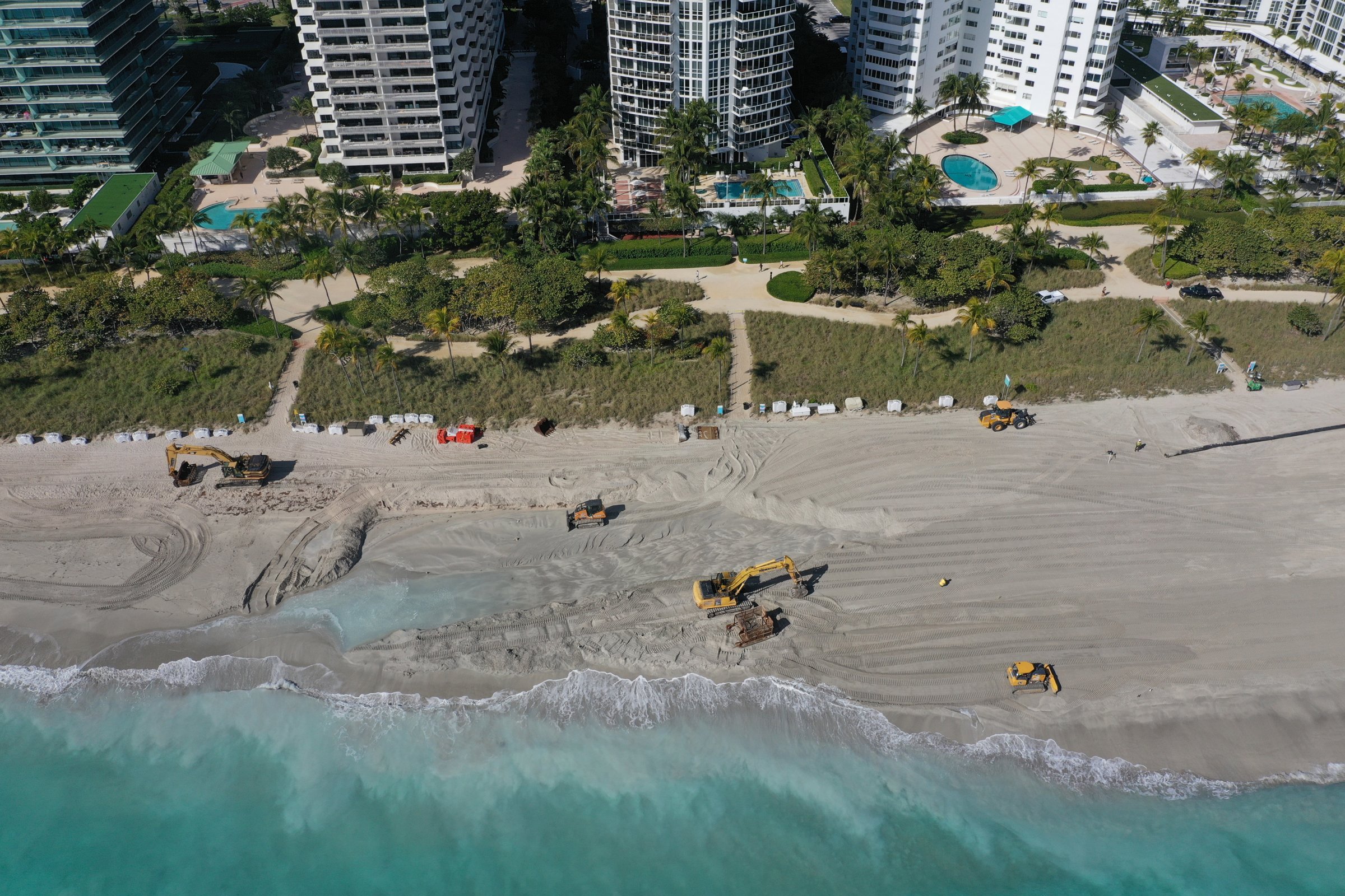 Aerial view of heavy equipment regrading a beach